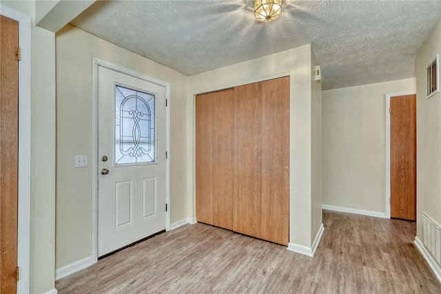 entryway featuring a textured ceiling and light hardwood / wood-style floors