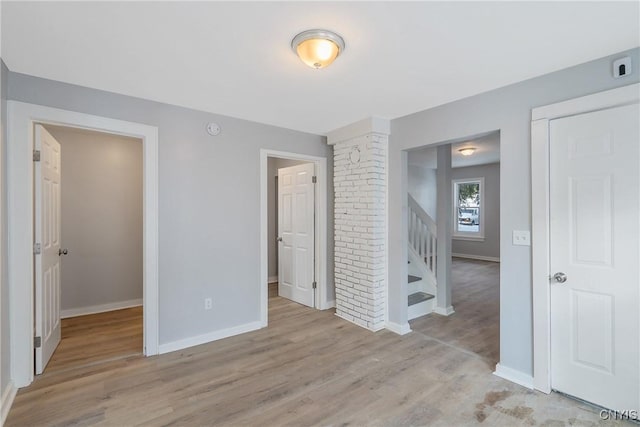 unfurnished bedroom featuring ensuite bathroom and light hardwood / wood-style floors