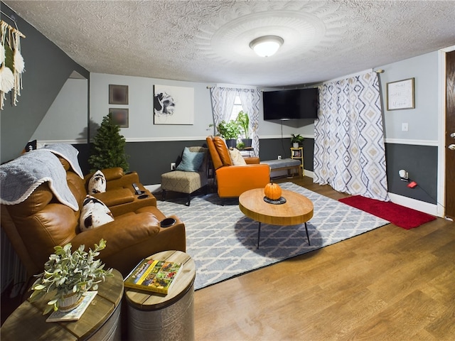 living room featuring wood-type flooring and a textured ceiling