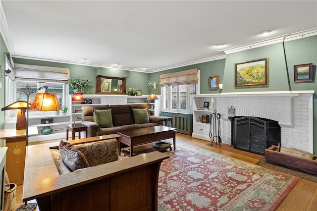 living room with ornamental molding, light hardwood / wood-style floors, and a fireplace