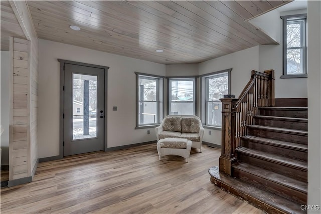 entrance foyer with wooden ceiling, a wealth of natural light, and light hardwood / wood-style floors