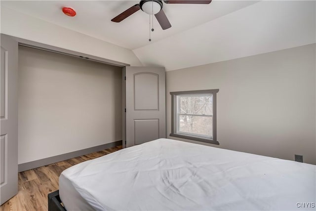 bedroom with ceiling fan, light wood-type flooring, and lofted ceiling