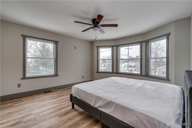 bedroom with pool table, light wood-type flooring, and ceiling fan