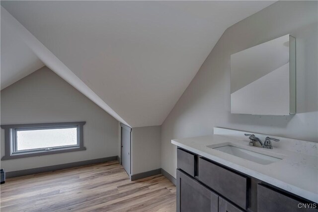 bonus room featuring lofted ceiling, light hardwood / wood-style flooring, and sink