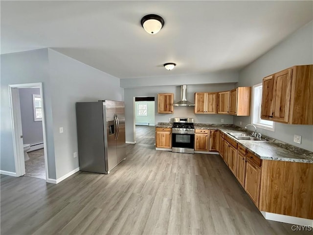 kitchen featuring baseboard heating, stainless steel appliances, light wood-type flooring, wall chimney exhaust hood, and sink