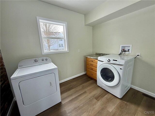 clothes washing area with hardwood / wood-style floors and independent washer and dryer