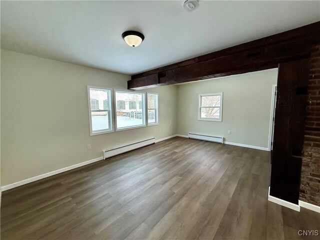 spare room with hardwood / wood-style floors and a baseboard heating unit