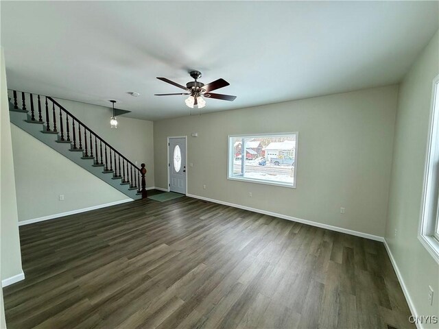 unfurnished living room featuring ceiling fan, plenty of natural light, and dark hardwood / wood-style floors