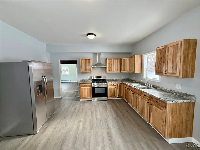 kitchen featuring stainless steel appliances, wall chimney exhaust hood, a wealth of natural light, and sink