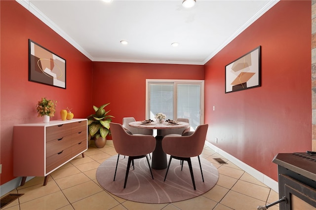 dining area with light tile patterned floors and crown molding