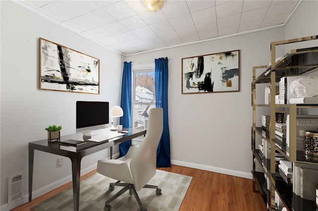 home office featuring wood-type flooring and ornamental molding