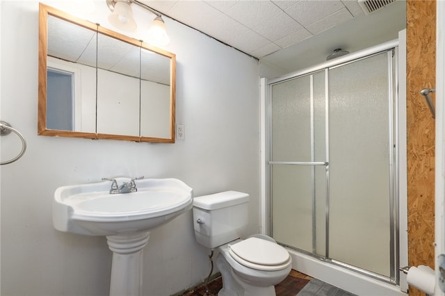 bathroom with a shower with shower door and toilet