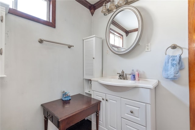 bathroom featuring vanity, a healthy amount of sunlight, and crown molding