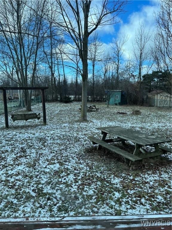 yard layered in snow with a shed