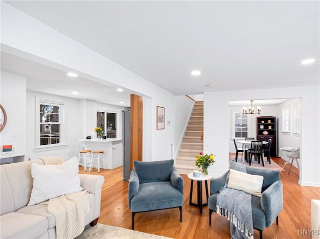 living room featuring light hardwood / wood-style flooring and an inviting chandelier