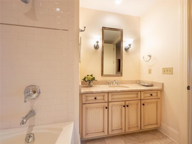 bathroom with tiled shower / bath combo, tile patterned floors, and vanity