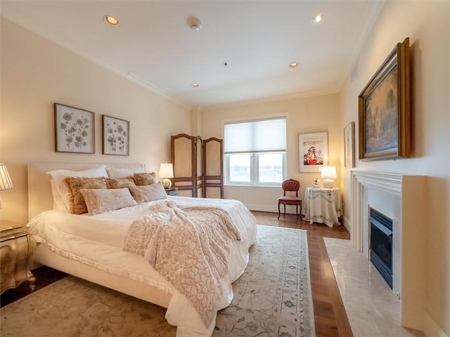 bedroom with crown molding and hardwood / wood-style floors