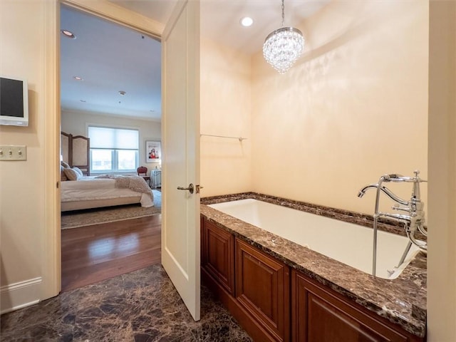 bathroom featuring a washtub and a chandelier