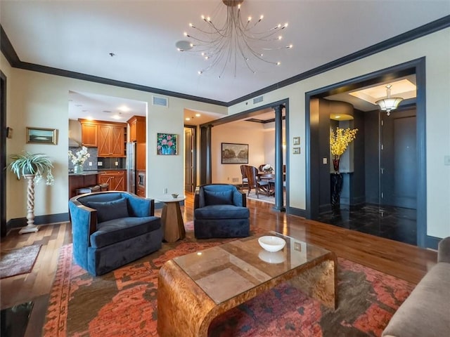 living room featuring an inviting chandelier, ornamental molding, and hardwood / wood-style floors