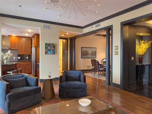 living room featuring crown molding, dark hardwood / wood-style floors, and ornate columns