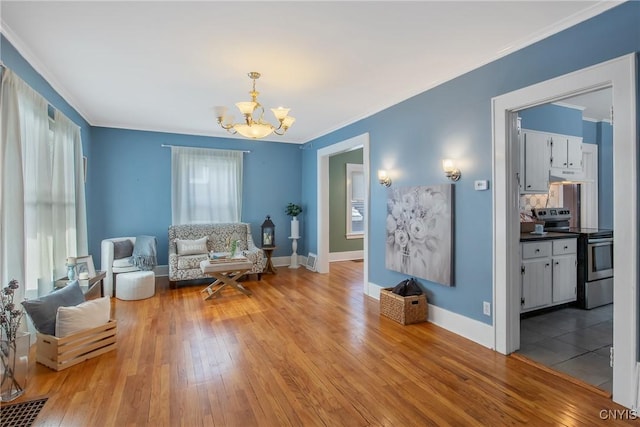 living area featuring an inviting chandelier, ornamental molding, plenty of natural light, and light hardwood / wood-style flooring