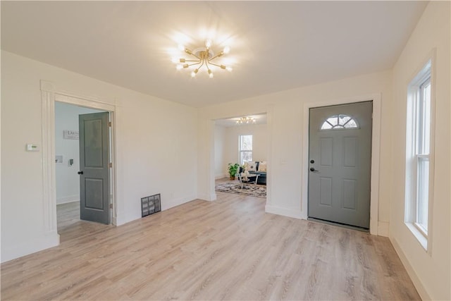 entryway with a chandelier and light wood-type flooring