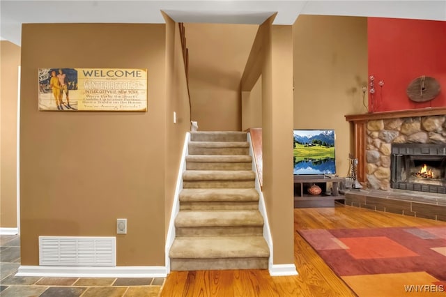 stairs with a stone fireplace