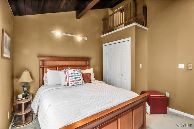 carpeted bedroom featuring a closet, lofted ceiling with beams, and wooden ceiling