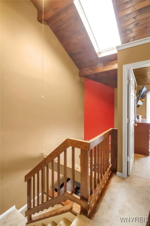 stairway featuring lofted ceiling with beams, wood ceiling, and carpet