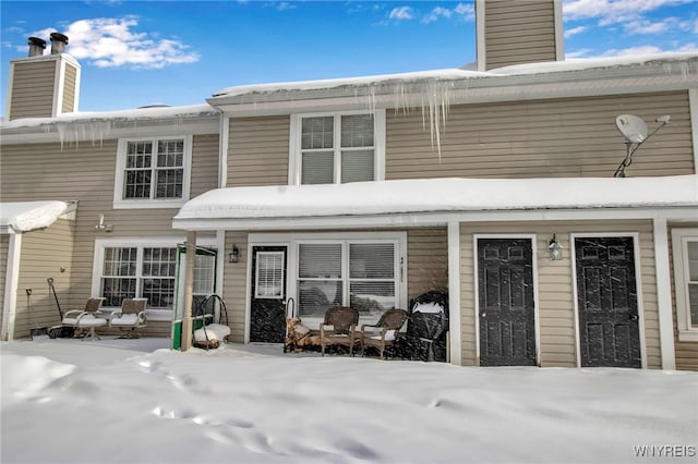 view of snow covered rear of property