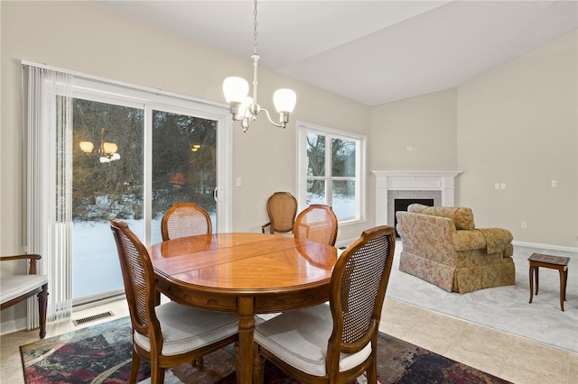 tiled dining room featuring a tile fireplace and a notable chandelier