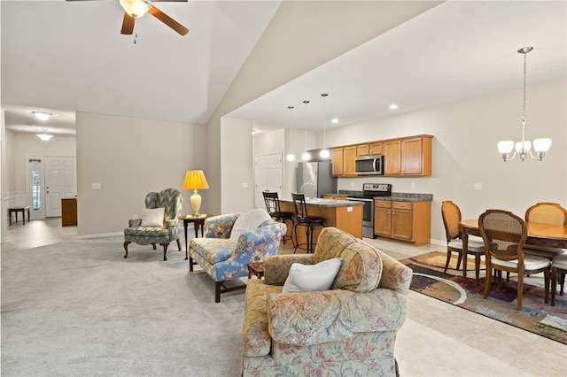 carpeted living room with vaulted ceiling and ceiling fan with notable chandelier