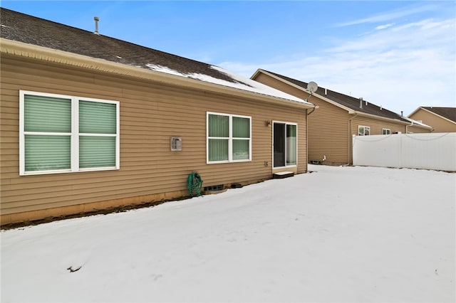 view of snow covered back of property