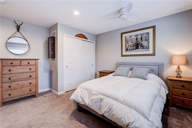 carpeted bedroom with ceiling fan and a closet