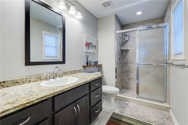 bathroom with toilet, walk in shower, and vanity