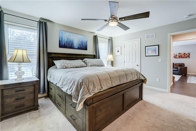 bedroom with ceiling fan and light colored carpet