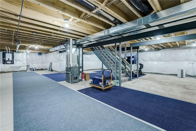 basement featuring electric panel and heating unit