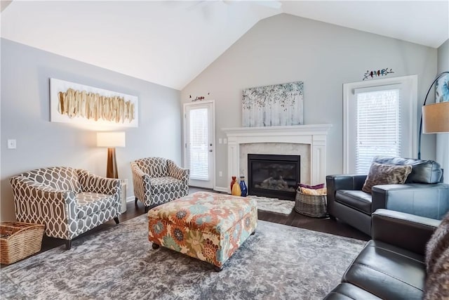 living room with dark wood-type flooring, lofted ceiling, and a fireplace