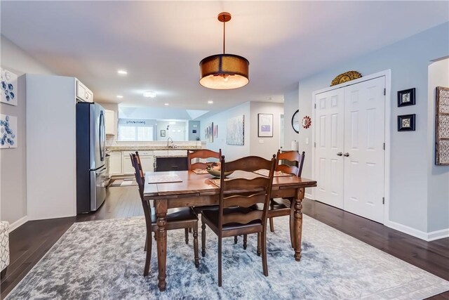 dining room with dark hardwood / wood-style flooring and sink