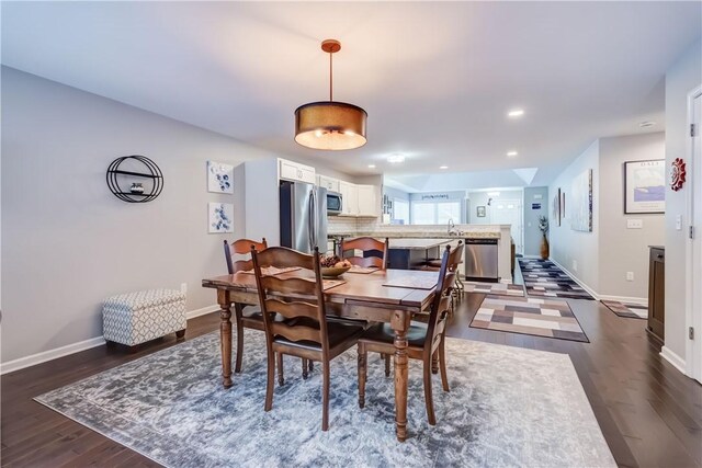 dining space featuring dark hardwood / wood-style flooring and sink