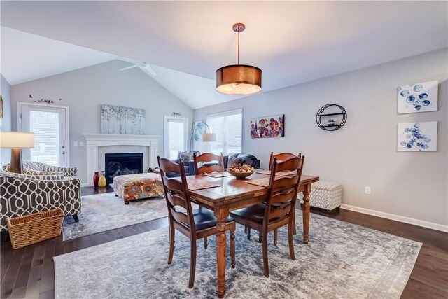 dining room featuring ceiling fan, a wealth of natural light, dark hardwood / wood-style floors, and vaulted ceiling