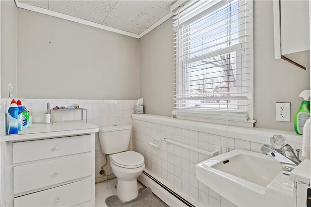 bathroom with toilet, tile walls, a baseboard heating unit, ornamental molding, and sink