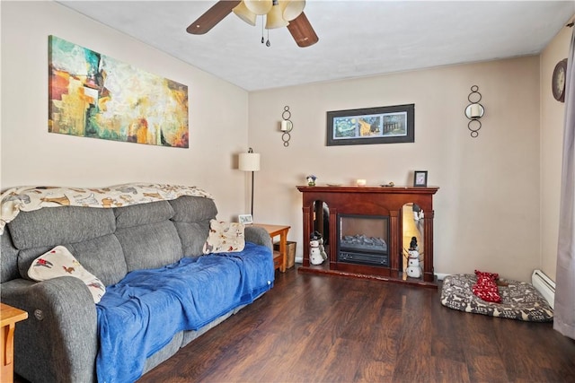 living room featuring ceiling fan, dark hardwood / wood-style floors, and a baseboard heating unit