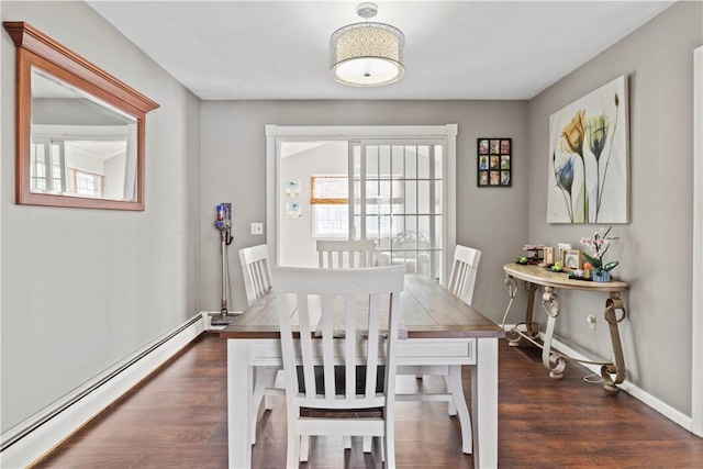 dining room featuring dark wood-type flooring and a baseboard heating unit