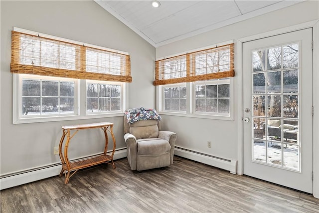 sitting room featuring lofted ceiling, baseboard heating, and hardwood / wood-style flooring