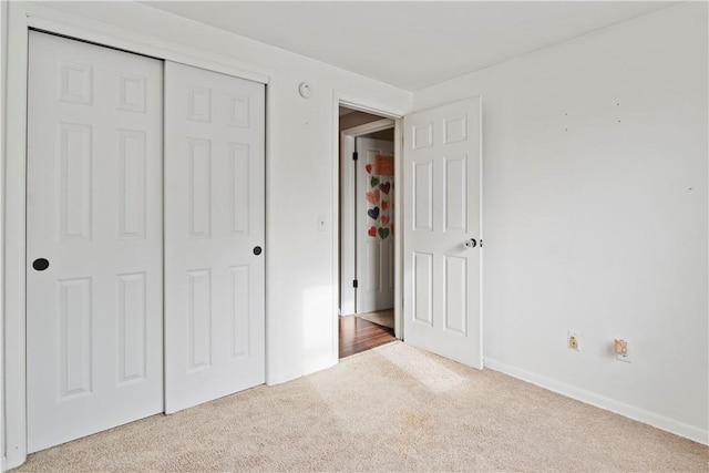 unfurnished bedroom featuring a closet and light carpet