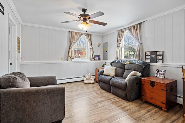 living room featuring light wood-type flooring, ceiling fan, a baseboard radiator, and crown molding