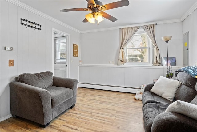 living room with a baseboard radiator, light wood-type flooring, ceiling fan, and ornamental molding