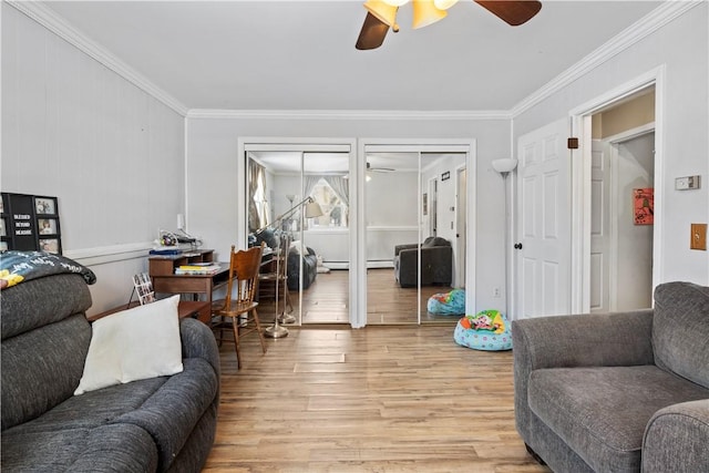 living room featuring baseboard heating, light wood-type flooring, ceiling fan, and crown molding