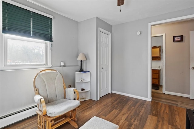 living area with ceiling fan, a baseboard radiator, and dark hardwood / wood-style flooring